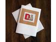 This cross stitch card features a cute little brown dinosaur